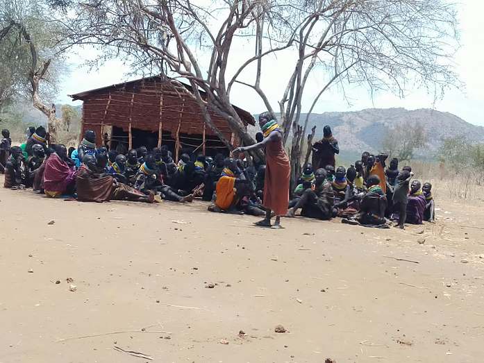 Residents meet under the acacia shade